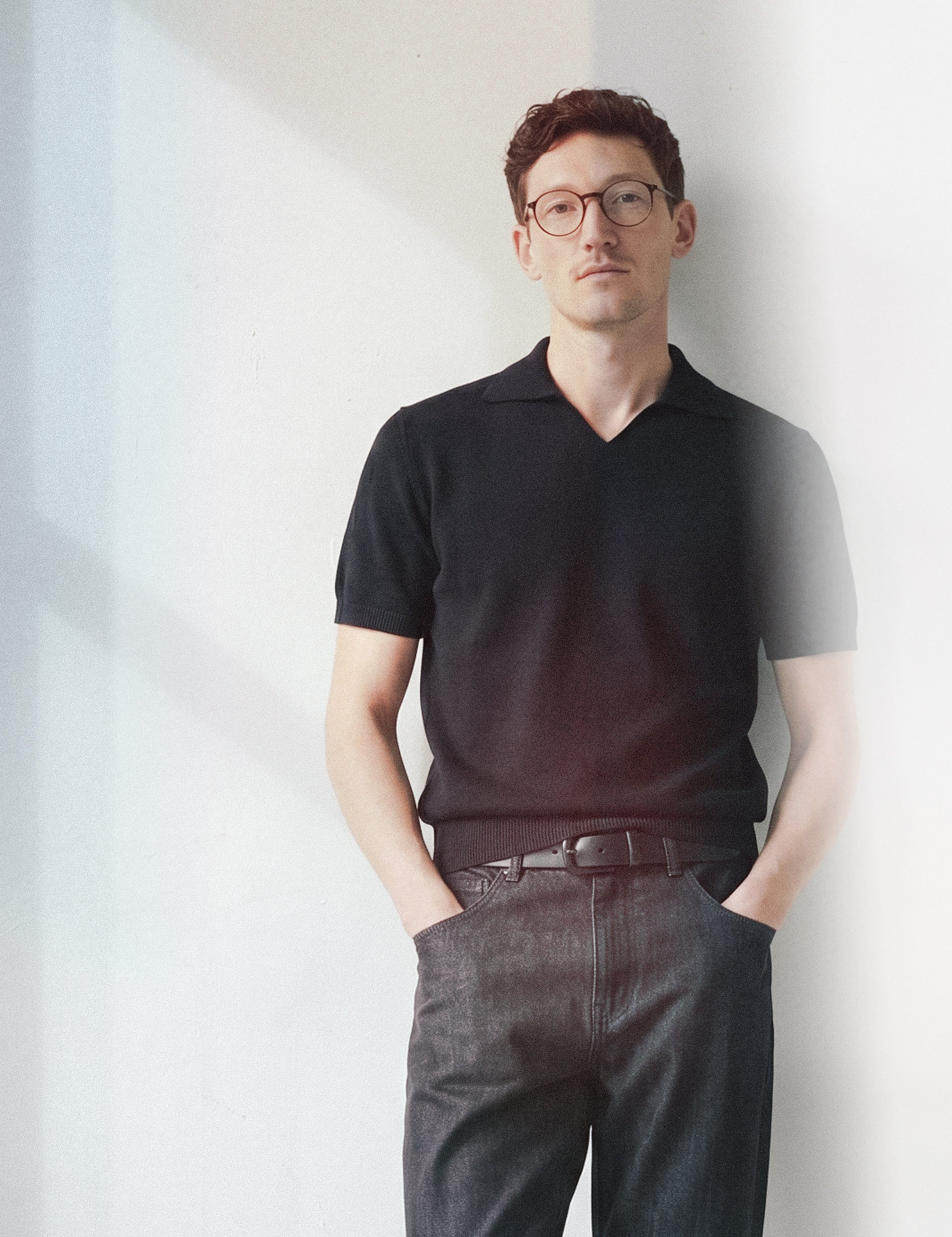 Limono Lemonheads Rose lifestyle portrait, man in black knit polo and dark denim against a white wall