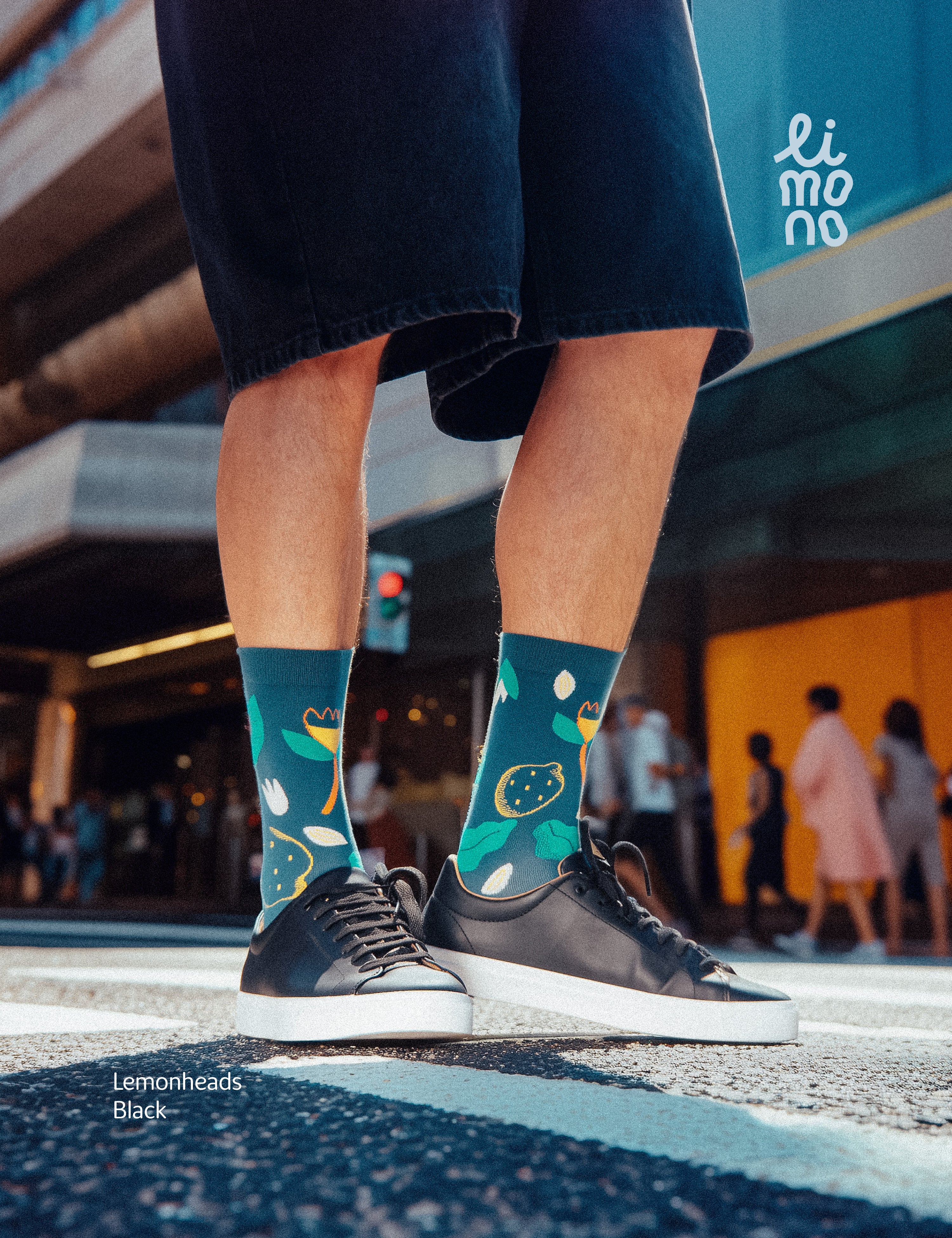 Cropped legs at crosswalk with black sneakers wearing Limono Lemonheads Black socks