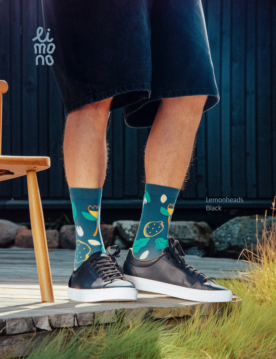 Cropped legs on wooden porch with black sneakers wearing Limono Lemonheads Black socks