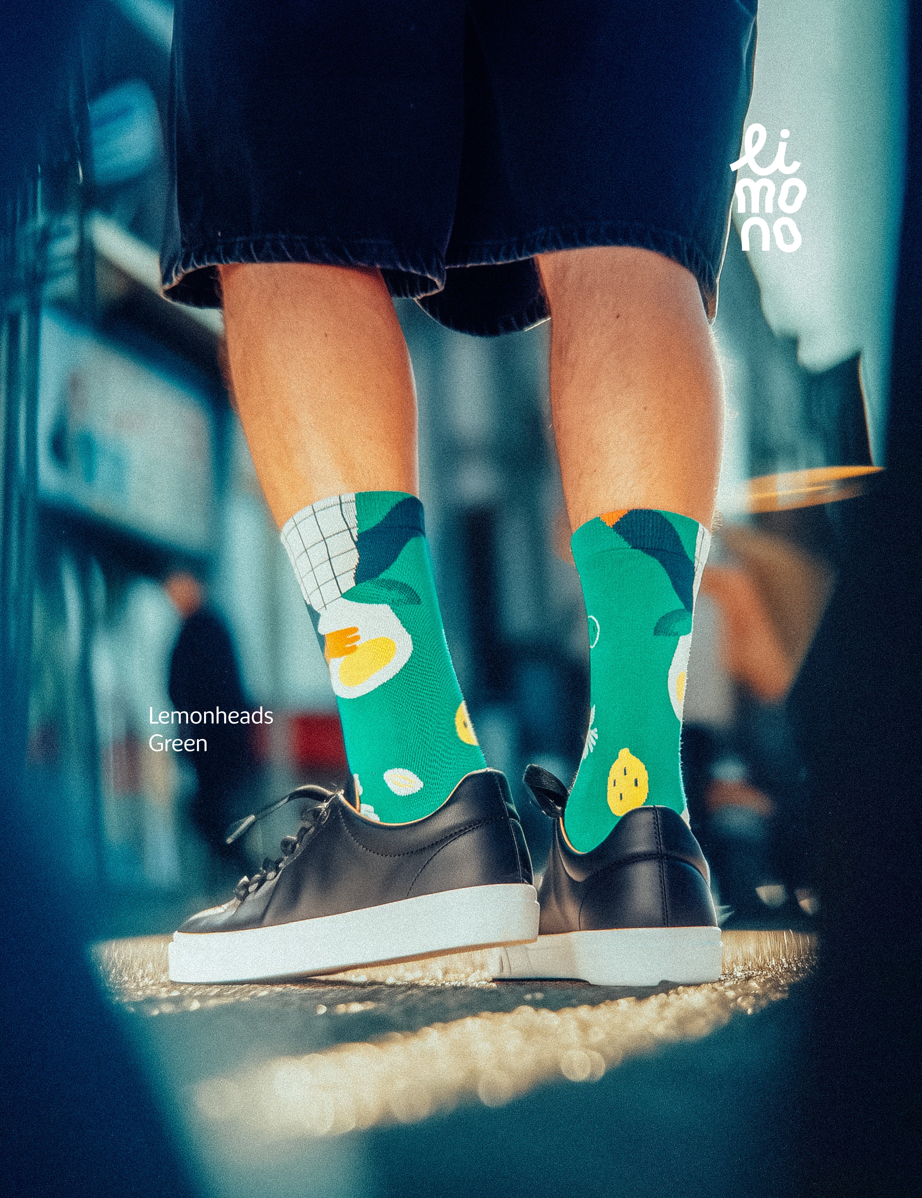 Cropped legs walking in the city with dark sneakers wearing Limono Lemonheads Green socks