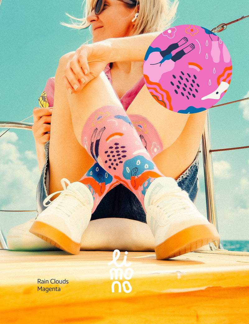Limono Socks Rain Clouds collection. Illustrated socks on trend made in Portugal. Organic combed cotton. Person wearing colorful socks with abstract patterns on a boat