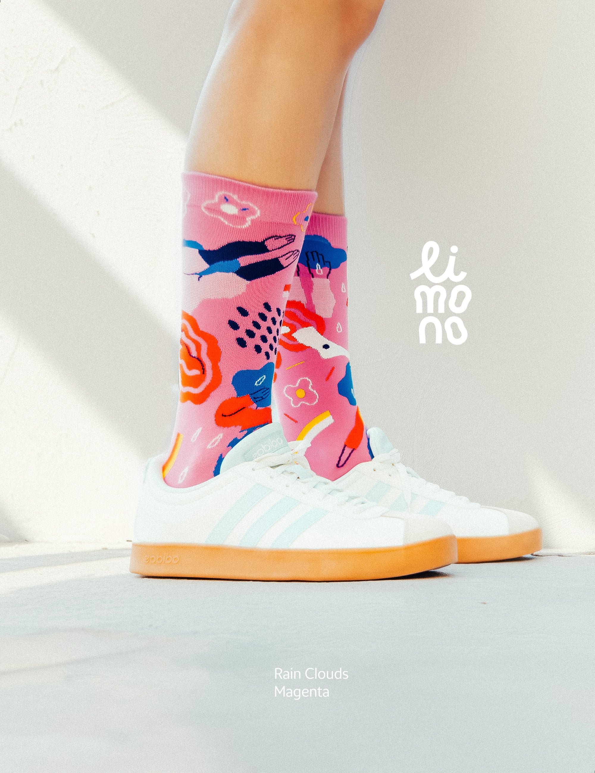 Limono Socks Rain Clouds collection. Illustrated socks on trend made in Portugal. Organic combed cotton. Colorful socks with whale design worn by a person, on a light background with 'limono' branding.