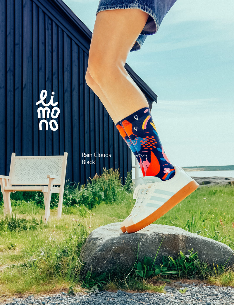 Limono Socks Rain Clouds collection. Illustrated socks on trend made in Portugal. Organic combed cotton. Person wearing colorful socks with a scenic background