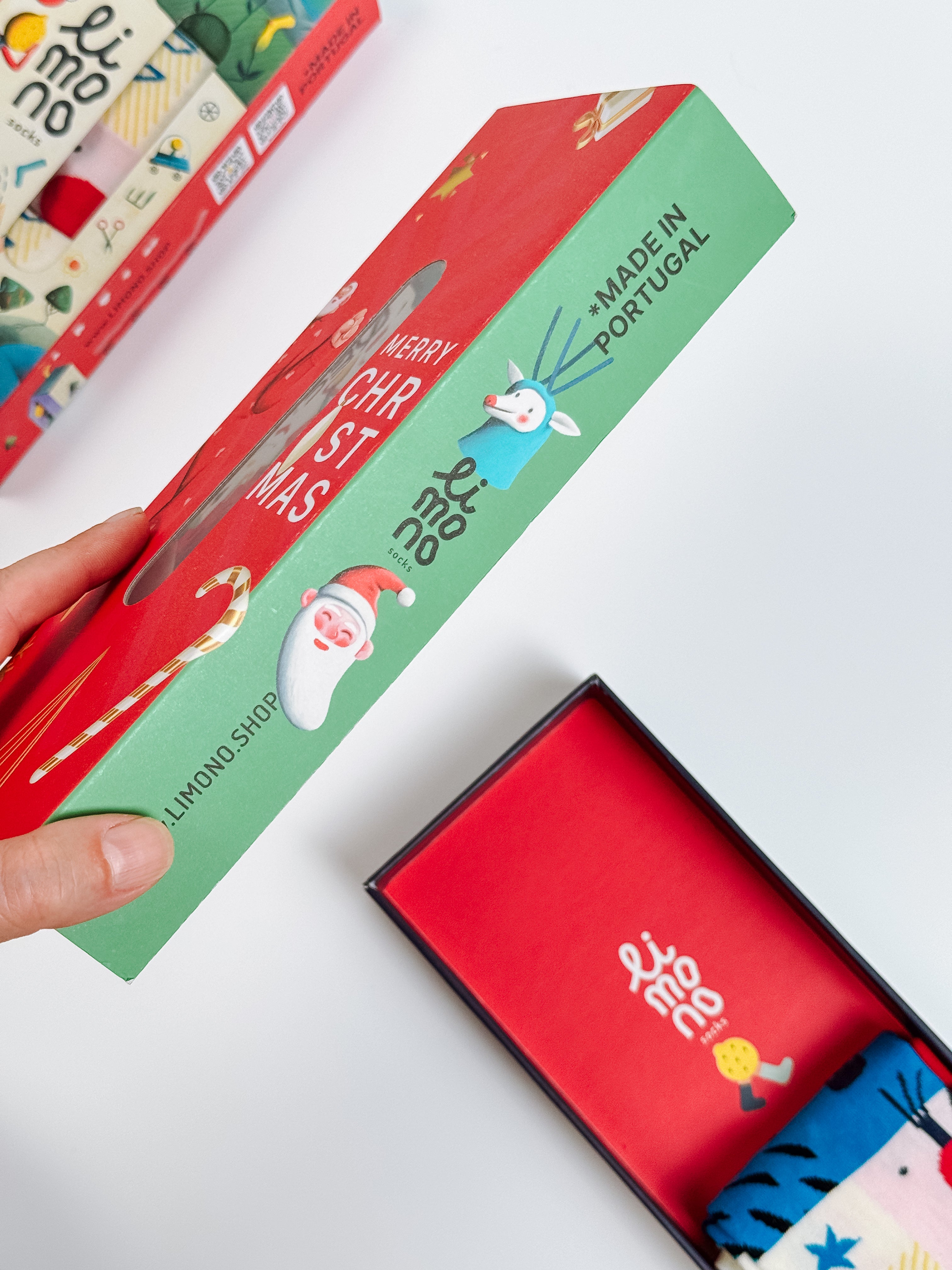 Limono Christmas gift box held in hand with Santa and reindeer characters, Made in Portugal