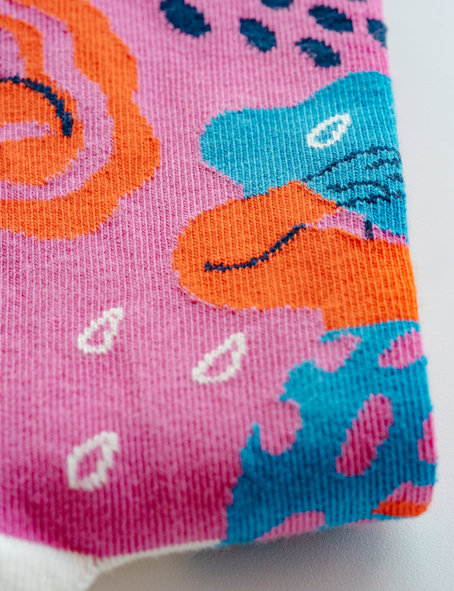 Limono Rain Clouds Magenta socks jacquard knit macro showing cloud-head character on magenta cotton