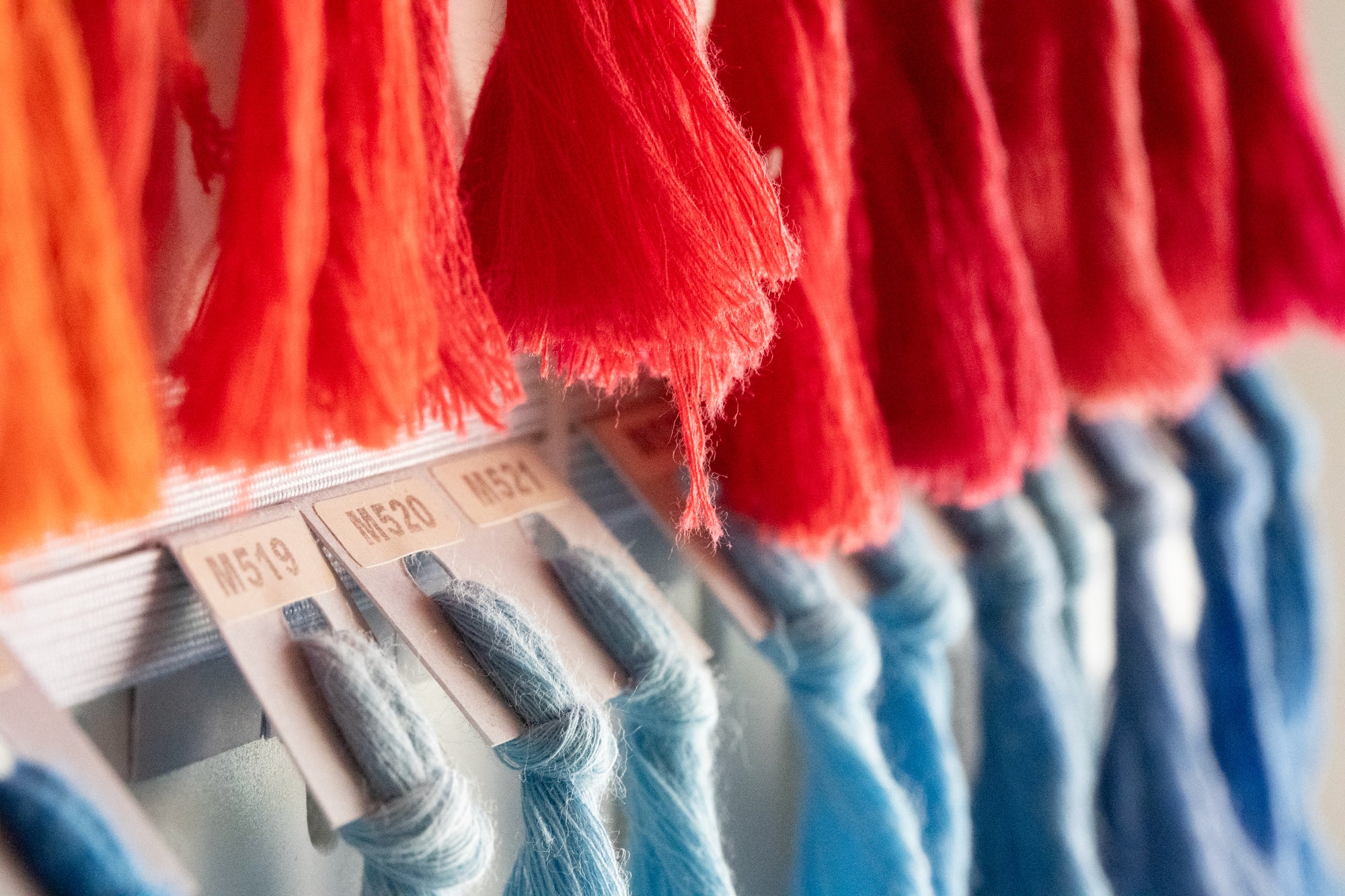 Limono studio yarn rack, coral cones above blue cones with labels M519 M520 M521