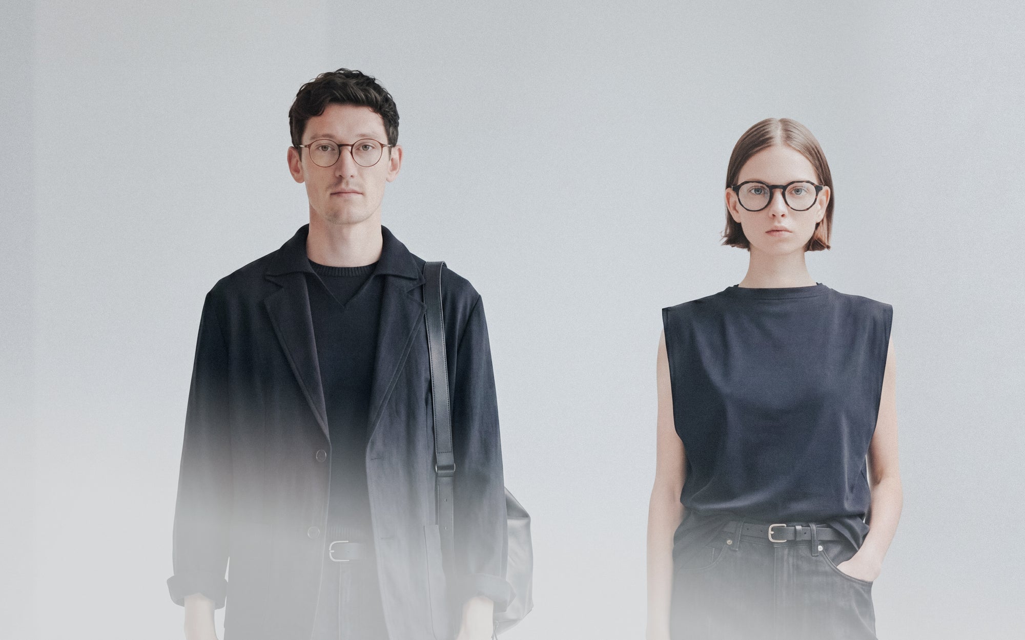 Editorial diptych of man and woman with glasses in dark tops fading into white backdrop