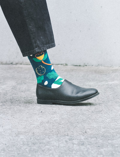 Cropped tip-toe profile in dark jeans and leather slip-on wearing Limono Lemonheads Black sock