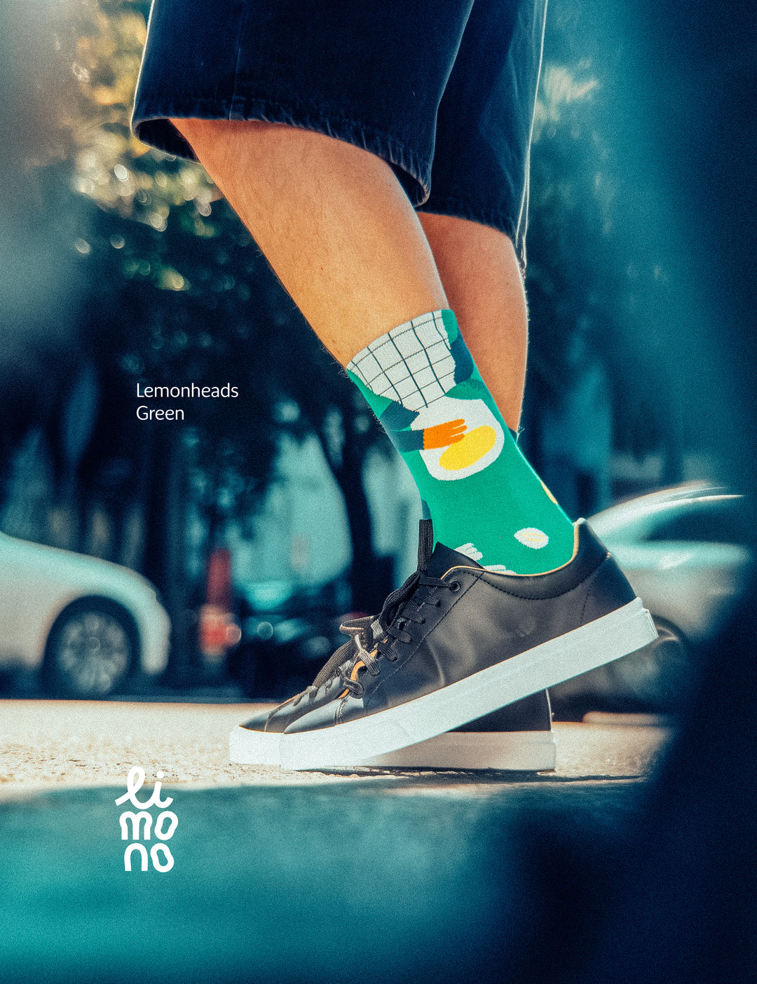 Cropped legs in street with car blur and black sneakers wearing Limono Lemonheads Green socks