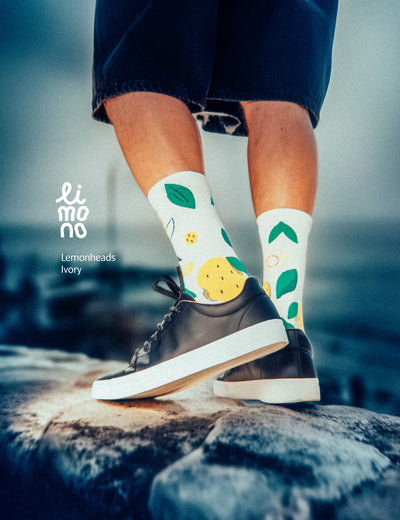 Limono Lemonheads Ivory socks worn with black sneakers and dark blue trousers in moody dusk light