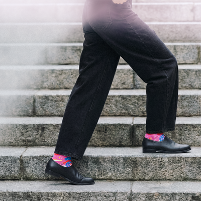 Limono Rain Clouds Magenta socks worn with dark jeans and black loafers on granite stairs