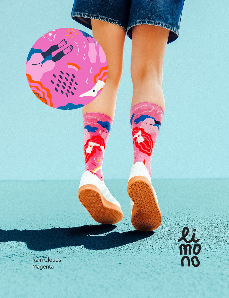 Limono Socks Rain Clouds collection. Illustrated socks on trend made in Portugal. Organic combed cotton.  Person wearing colorful socks with a blue background and 'limono' brand logo.