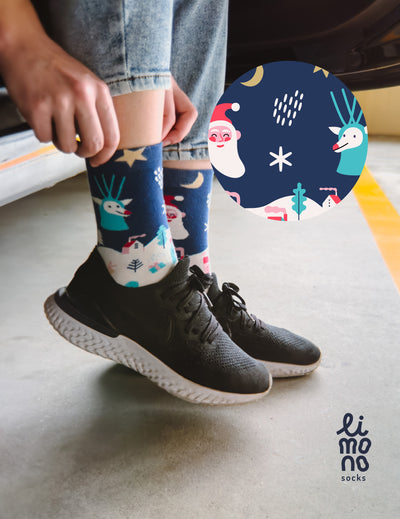 Limono Christmas Navy socks worn with black sneakers, Santa and deer illustration overlay