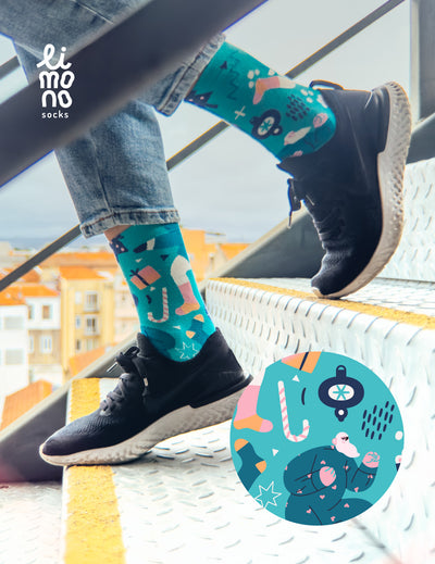 Limono Christmas Turquoise socks worn with black sneakers on metal stairs, dancing Santa illustration overlay