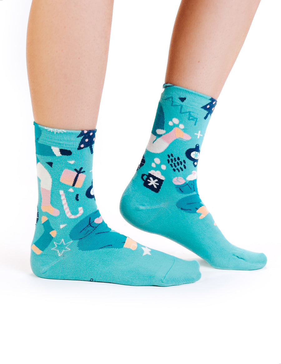 Limono Christmas Turquoise socks with dancing Santa, gift and cocoa motifs worn on legs