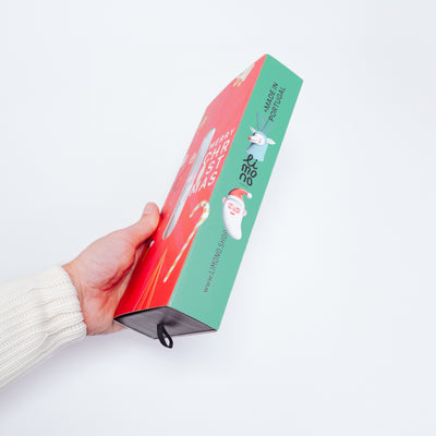 Hand in cream sweater holding the Limono Christmas gift box side view, Made in Portugal
