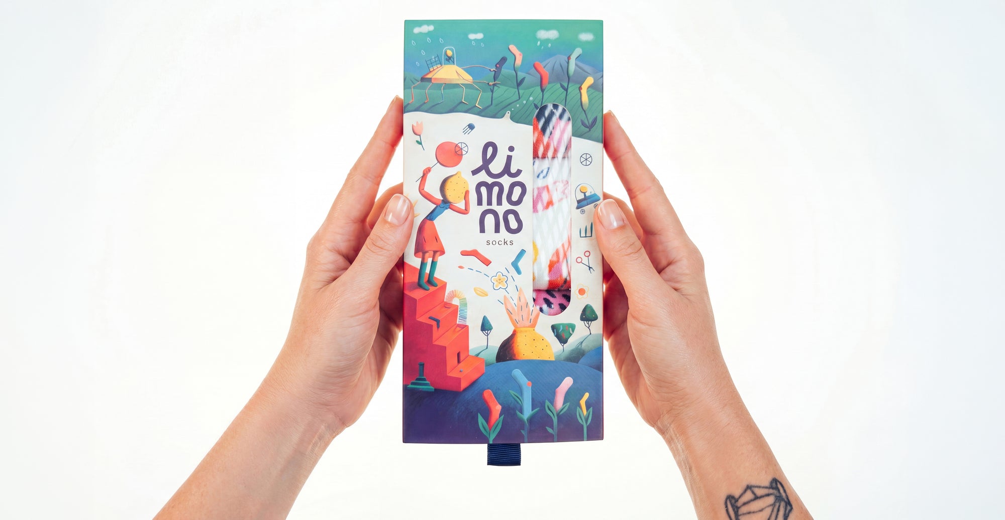 Two hands holding the Limono illustrated socks gift box centered on white
